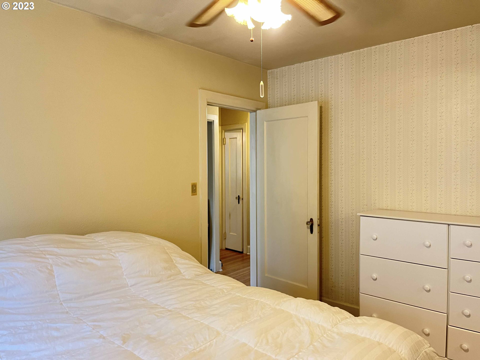 611 Laurel Street Florence, OR 97439 - Photo 25 of 32 a bedroom with a bed and a chandelier