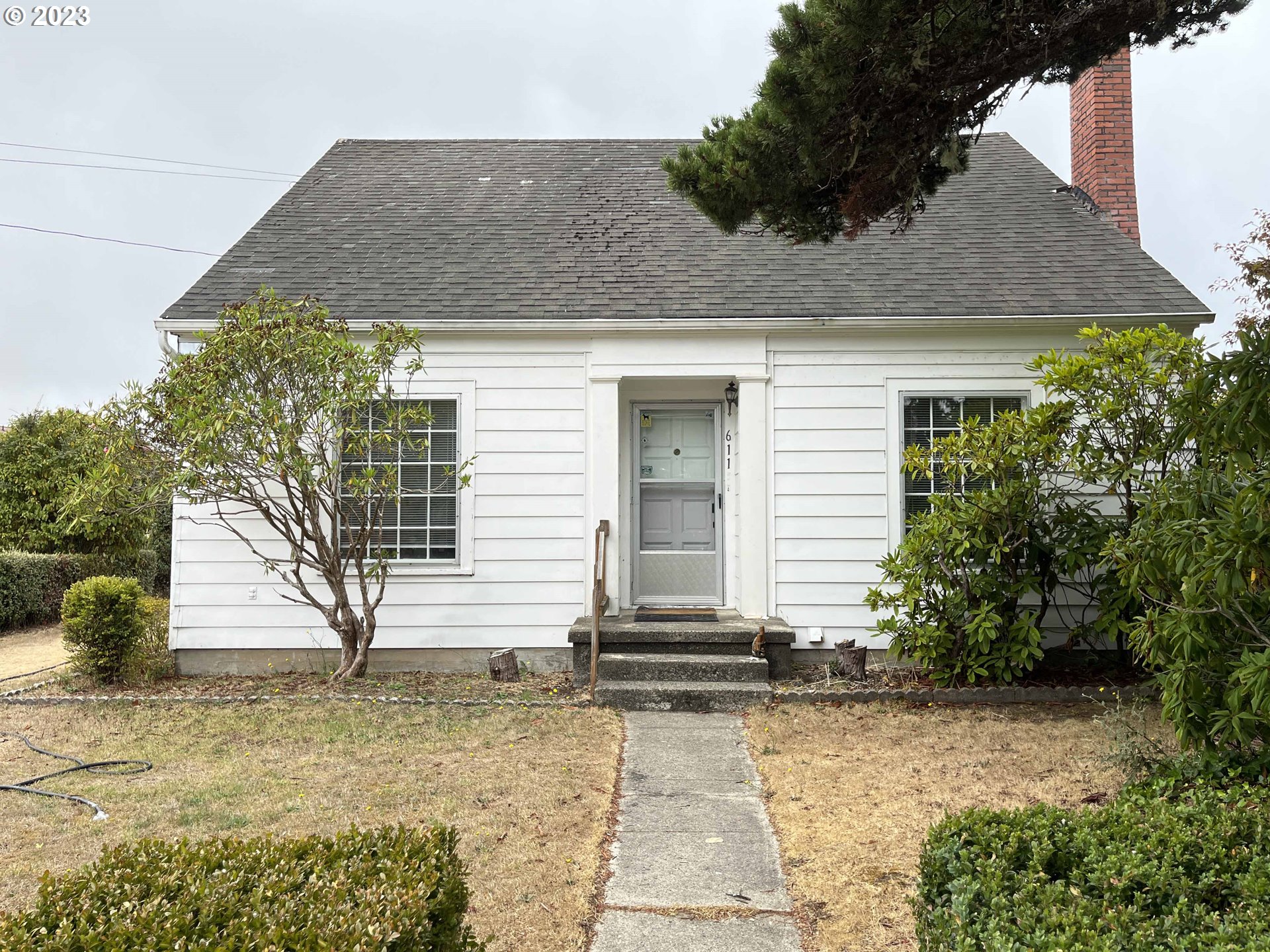 611 Laurel Street Florence, OR 97439 - Photo 4 of 32 a front view of a house with garden