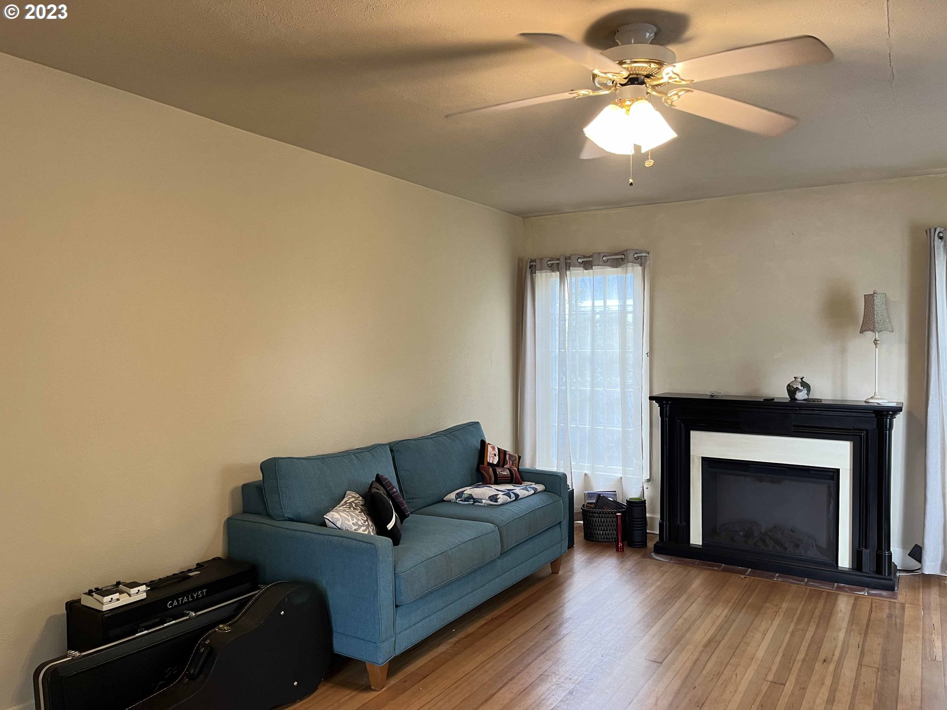 611 Laurel Street Florence, OR 97439 - Photo 9 of 32 a living room with furniture a fireplace and a ceiling fan