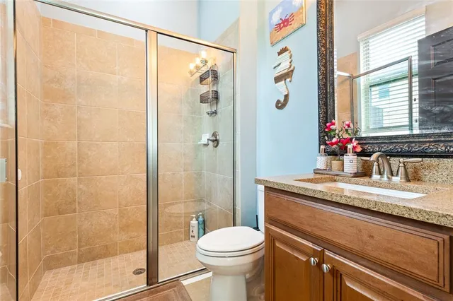 a bathroom with a granite countertop sink toilet and shower