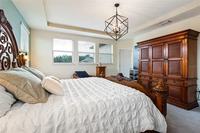 a bedroom with a bed a dresser and flat screen tv