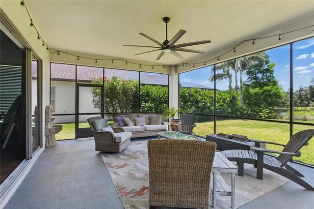 a living room with patio furniture and a floor to ceiling window