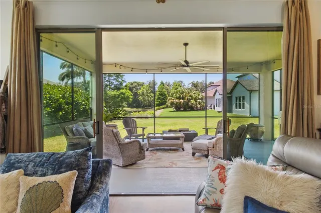 a living room with patio furniture and a floor to ceiling window