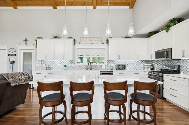 a kitchen with granite countertop white cabinets and stainless steel appliances