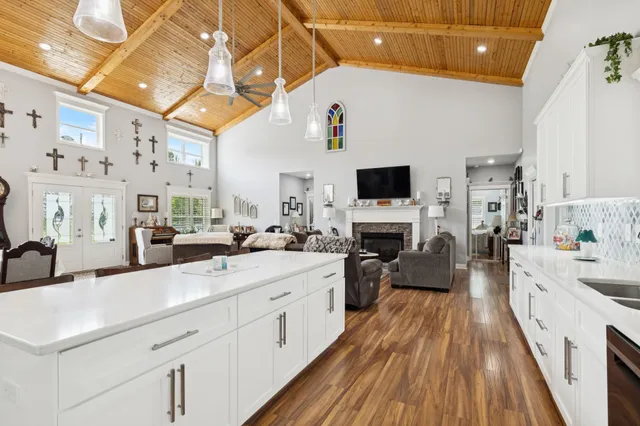 a large white kitchen with lots of counter space a sink and appliances