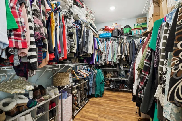 a view of walk in closet with clothes and shoes