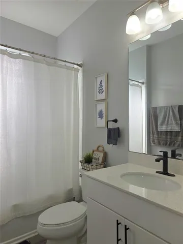 a bathroom with a sink a mirror a toilet and shower