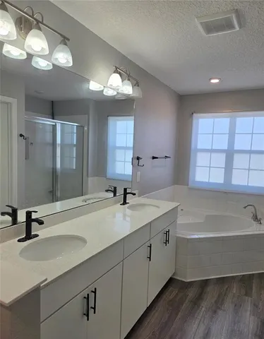 a bathroom with a tub sink and mirror