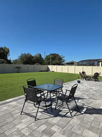 a view of a chairs and table in patio with a yard