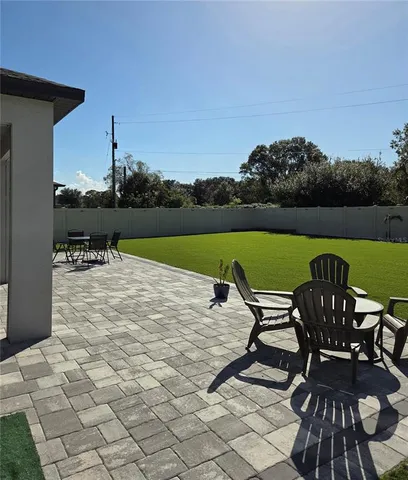 a view of a lake with table and chairs under an umbrella