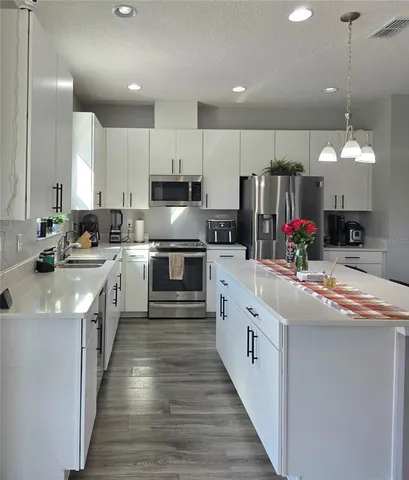 a kitchen with stainless steel appliances granite countertop a sink and cabinets