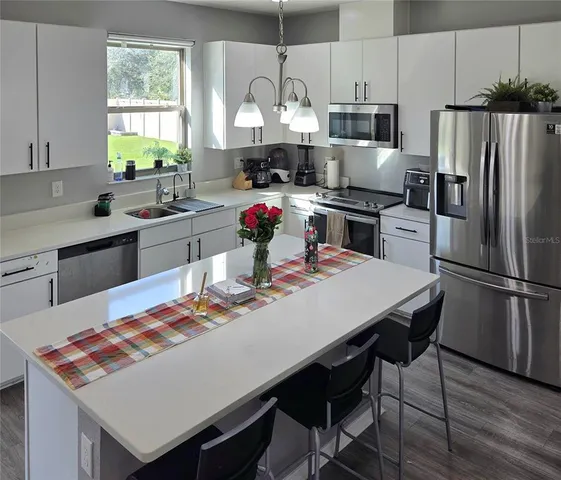 a kitchen with a stove a refrigerator and a dining table