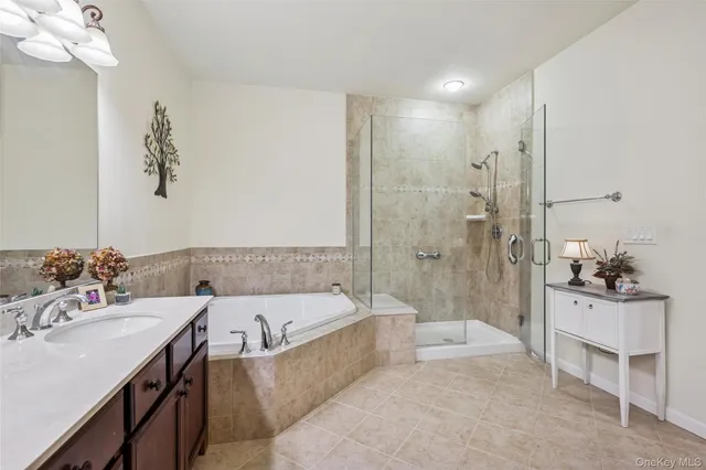 a bathroom with a tub a sink and mirror