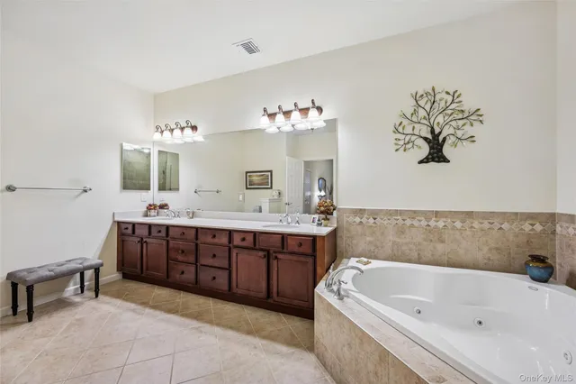 a bathroom with a tub sink and mirror