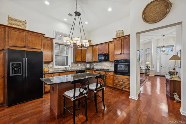 a kitchen with stainless steel appliances granite countertop a refrigerator a stove and a wooden floors