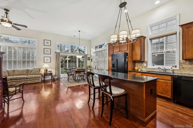 a dining room with wooden floor a chandelier a wooden table and chairs