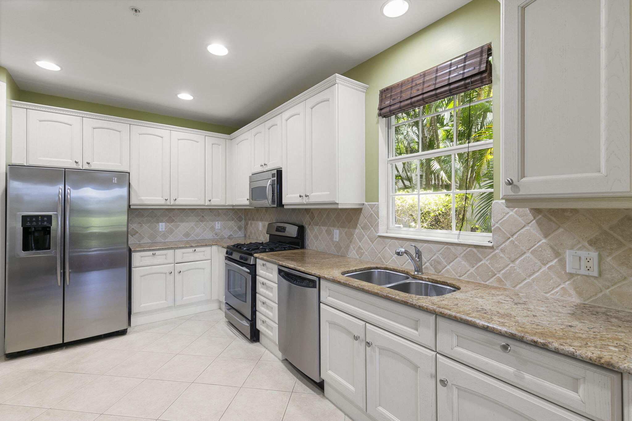 9066 Cascada Way, Unit 101 Naples, FL 34114 - Photo 14 of 51 a kitchen with stainless steel appliances granite countertop a sink stove and refrigerator