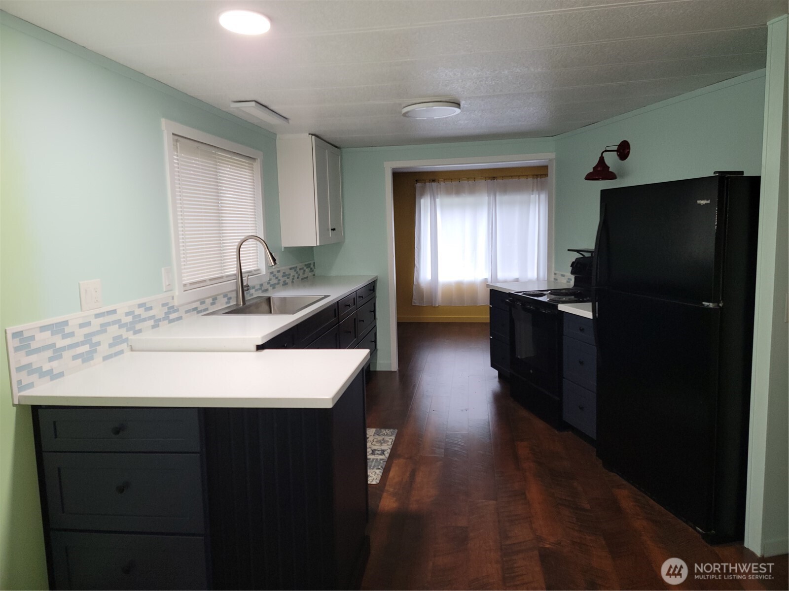 26506 Ridge Avenue Ocean Park, WA 98640 - Photo 13 of 28 a kitchen with a sink a refrigerator and cabinets