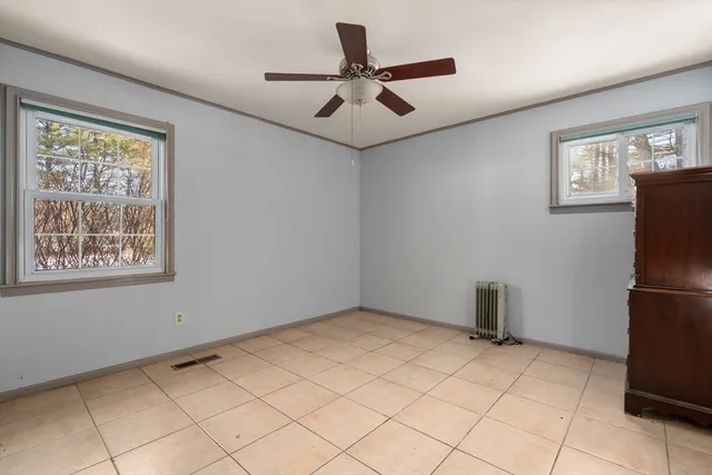 a view of empty room with window and ceiling fan