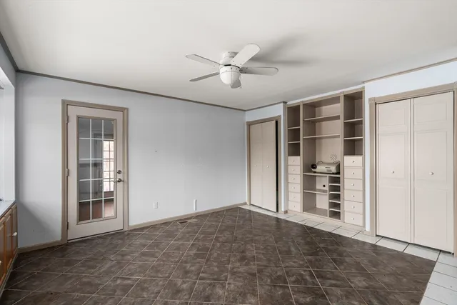 an empty room with closet and windows