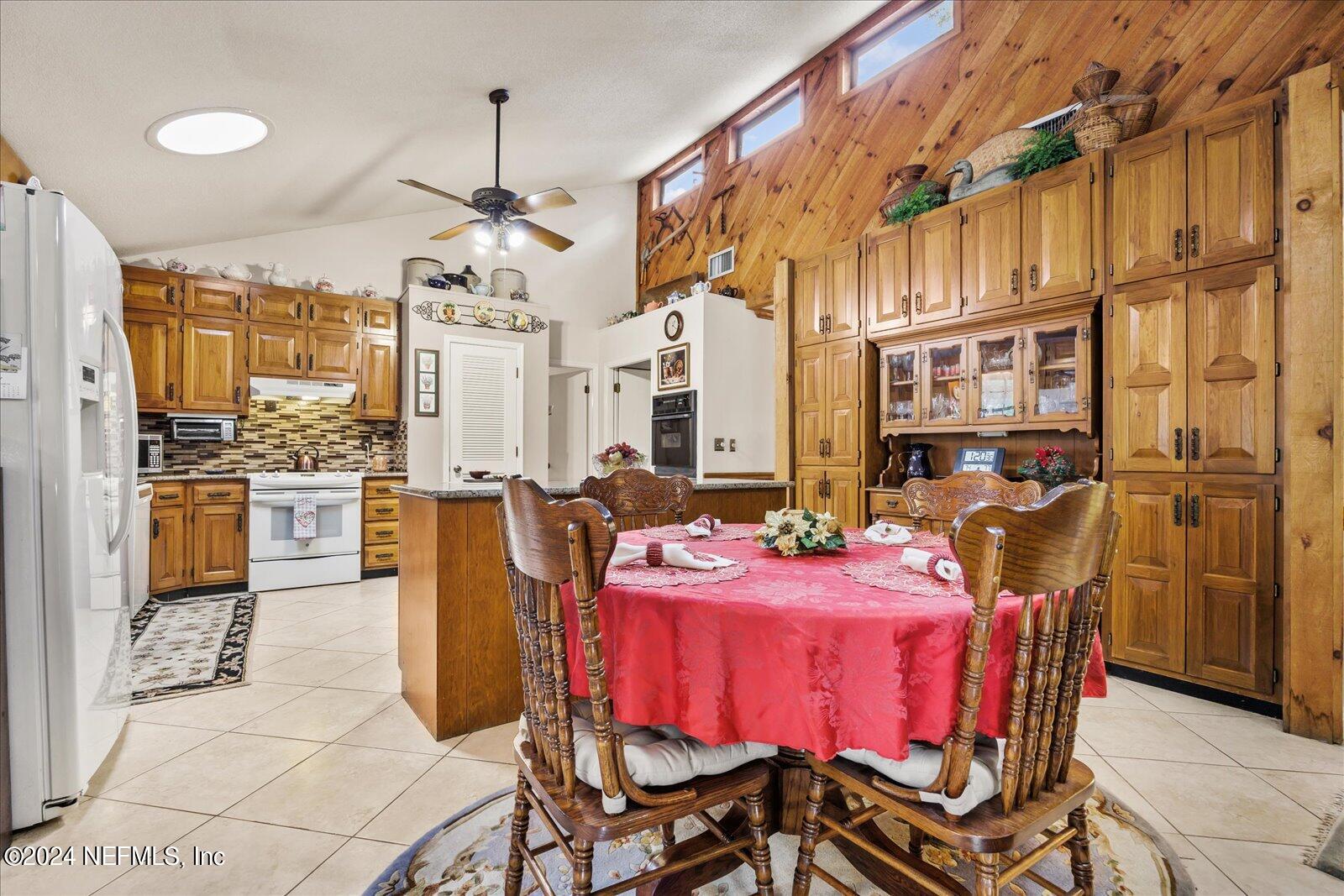 195 Horseman Club Road Palatka, FL 32177 - Photo 16 of 58 a dining hall with stainless steel appliances kitchen island granite countertop a dining table chairs refrigerator and cabinets