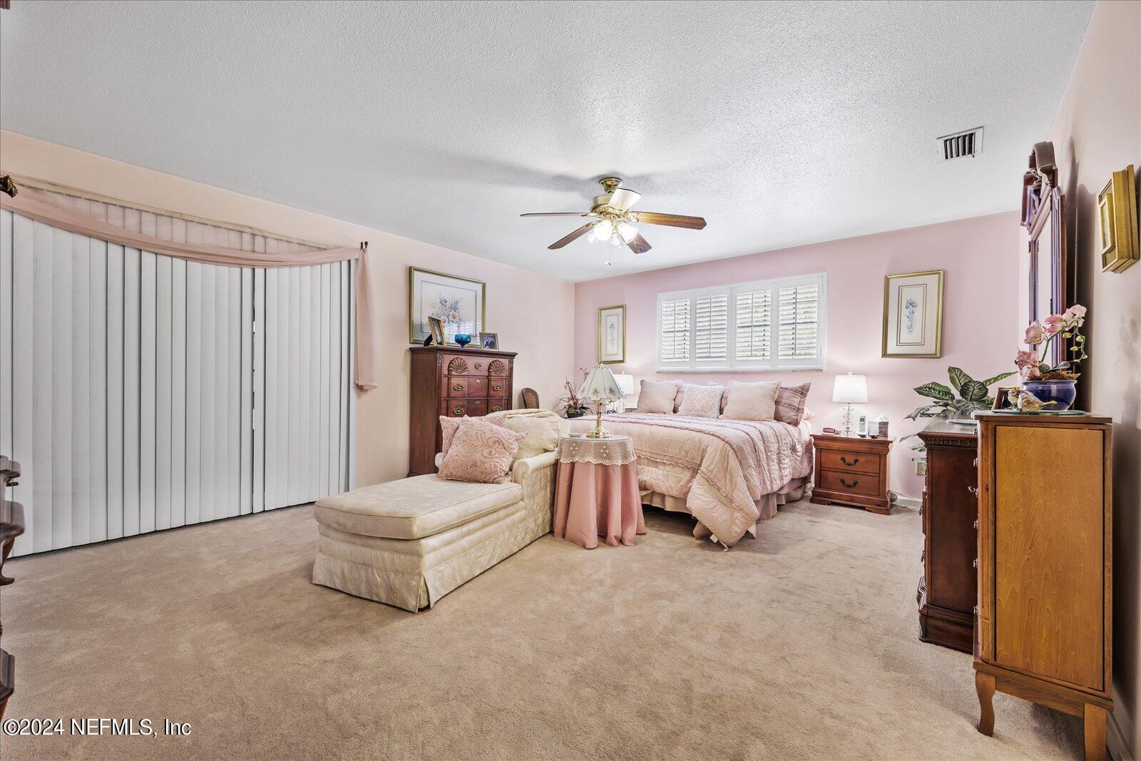195 Horseman Club Road Palatka, FL 32177 - Photo 26 of 58 a spacious bedroom with a bed and a chandelier