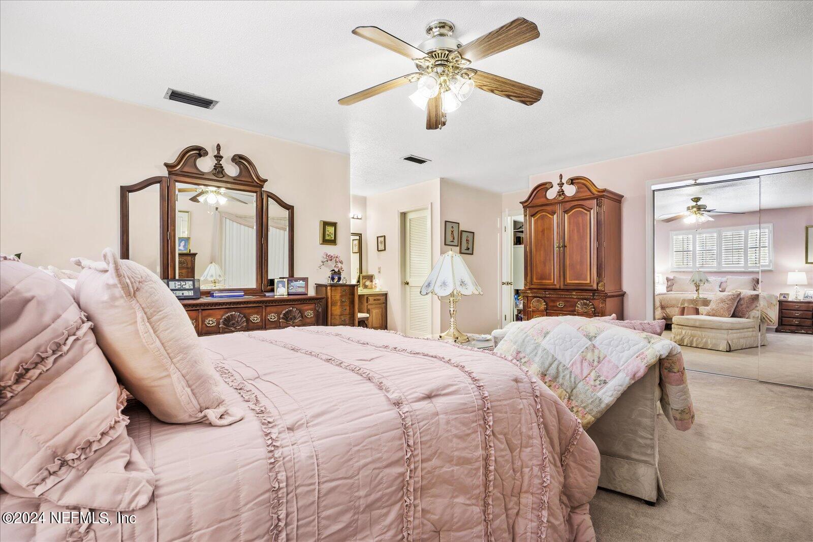 195 Horseman Club Road Palatka, FL 32177 - Photo 28 of 58 a bedroom with a large bed and a chandelier