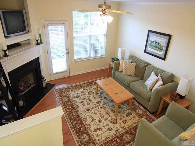 8302 City Loft Court Raleigh, NC 27613 - Photo 2 of 10 a living room with furniture a flat screen tv and a fireplace