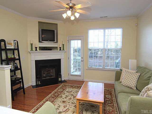 8302 City Loft Court Raleigh, NC 27613 - Photo 3 of 10 a living room with furniture a flat screen tv and a fireplace