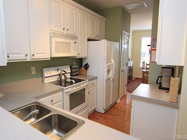8302 City Loft Court Raleigh, NC 27613 - Photo 5 of 10 a kitchen with a stove a refrigerator and a sink