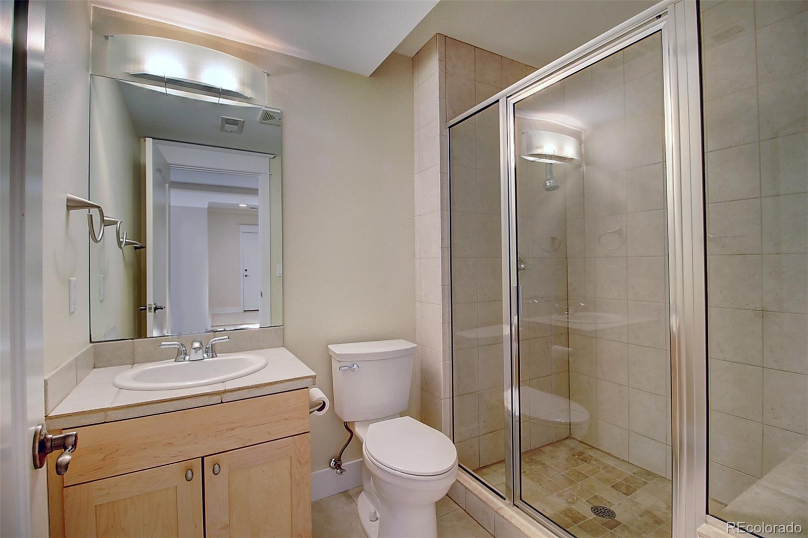 2942 4th Street Boulder, CO 80304 - Photo 19 of 22 a bathroom with a toilet a sink and glass door