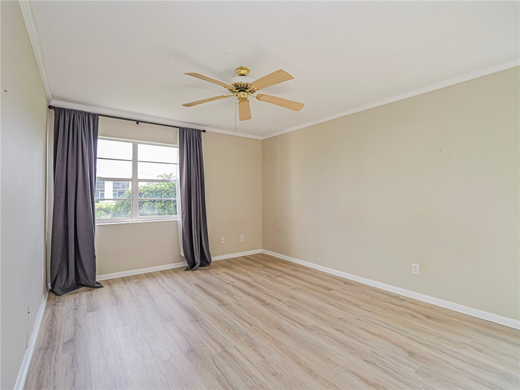 1860 Robalo Drive, Unit 105A Vero Beach, FL 32960 - Photo 11 of 35 an empty room with wooden floor and windows