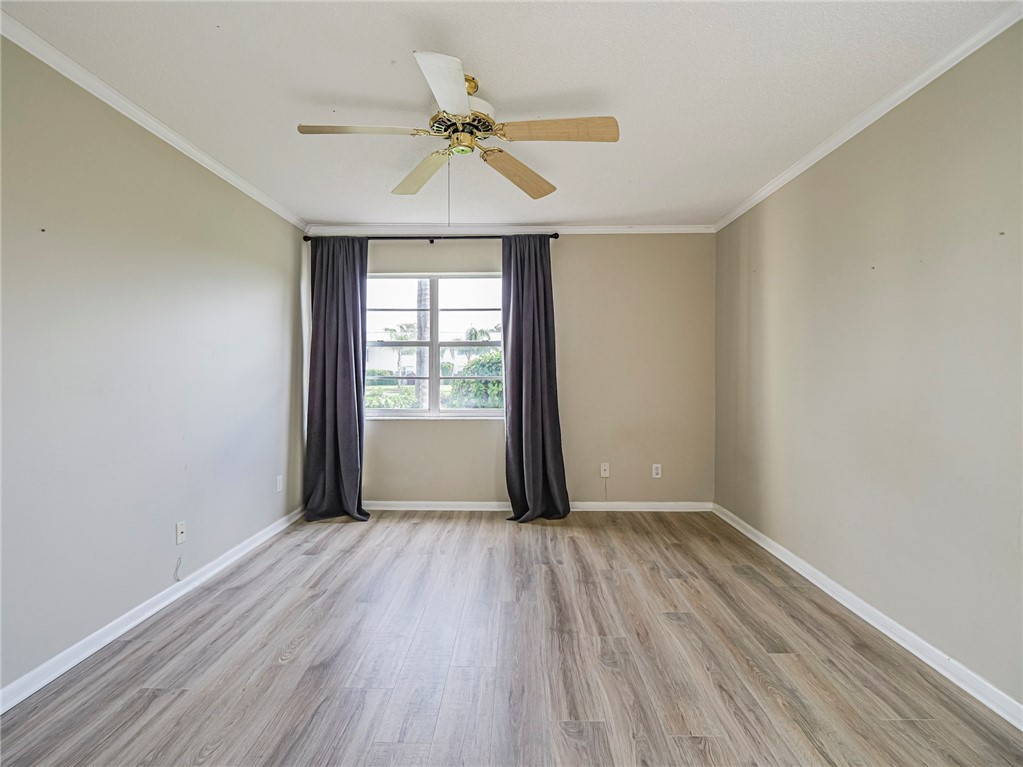 1860 Robalo Drive, Unit 105A Vero Beach, FL 32960 - Photo 12 of 35 wooden floor in an empty room with a window