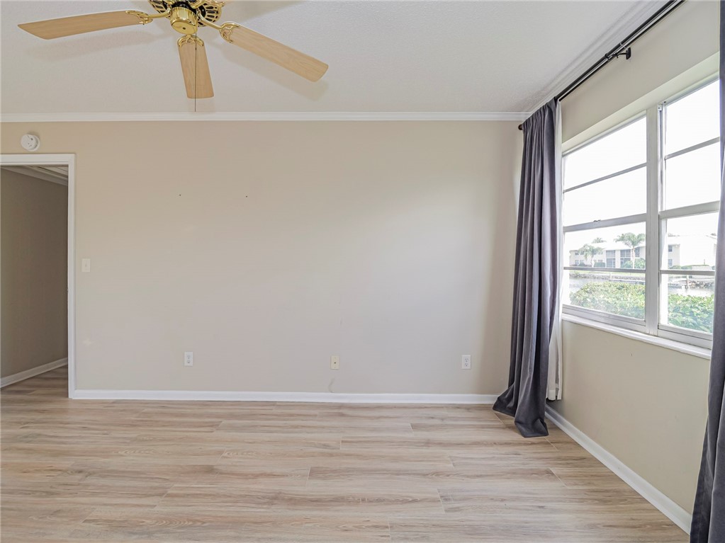 1860 Robalo Drive, Unit 105A Vero Beach, FL 32960 - Photo 14 of 35 a view of an empty room with a window and wooden floor