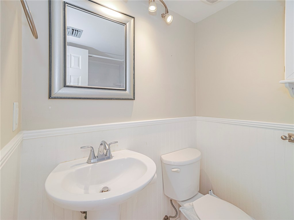 1860 Robalo Drive, Unit 105A Vero Beach, FL 32960 - Photo 15 of 35 a bathroom with a toilet a sink and mirror