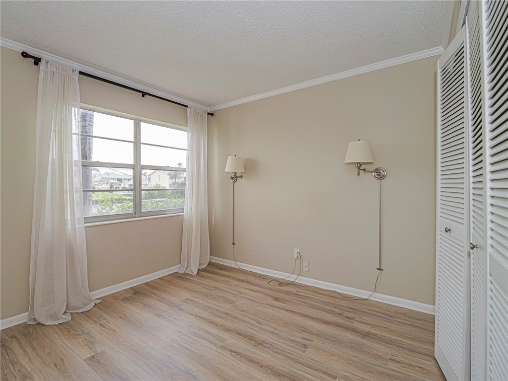 1860 Robalo Drive, Unit 105A Vero Beach, FL 32960 - Photo 18 of 35 a view of an empty room with wooden floor and a window