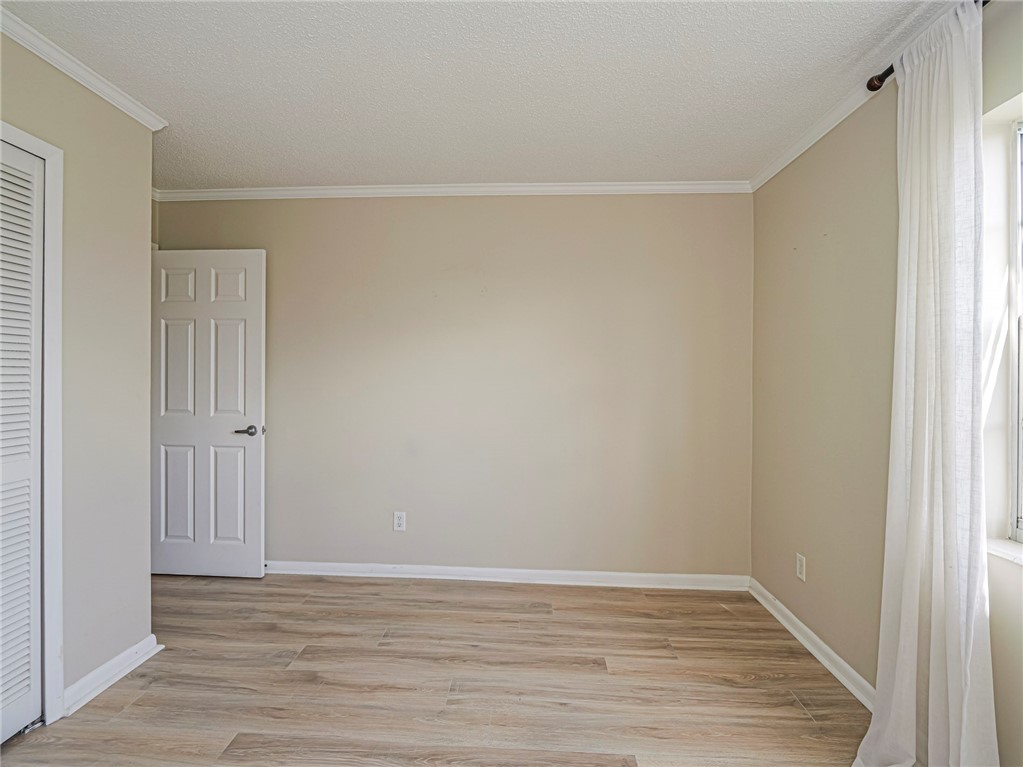 1860 Robalo Drive, Unit 105A Vero Beach, FL 32960 - Photo 19 of 35 a view of an empty room with wooden floor and a window