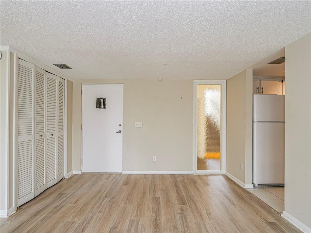 1860 Robalo Drive, Unit 105A Vero Beach, FL 32960 - Photo 3 of 35 a view of empty room with wooden floor and entryway