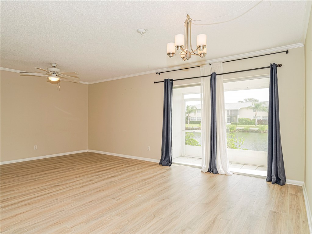 1860 Robalo Drive, Unit 105A Vero Beach, FL 32960 - Photo 9 of 35 a view of an empty room with wooden floor and a window