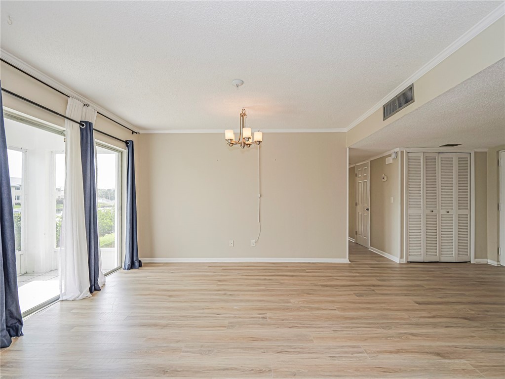 1860 Robalo Drive, Unit 105A Vero Beach, FL 32960 - Photo 10 of 35 a view of an empty room with wooden floor and a window
