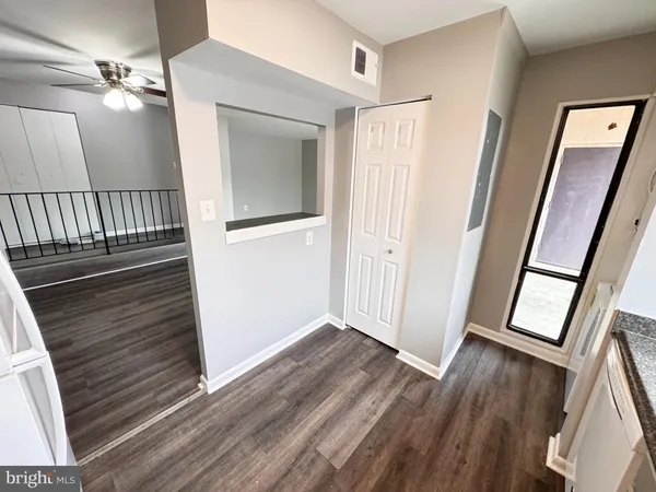 a view of a hallway with wooden floor and stairs