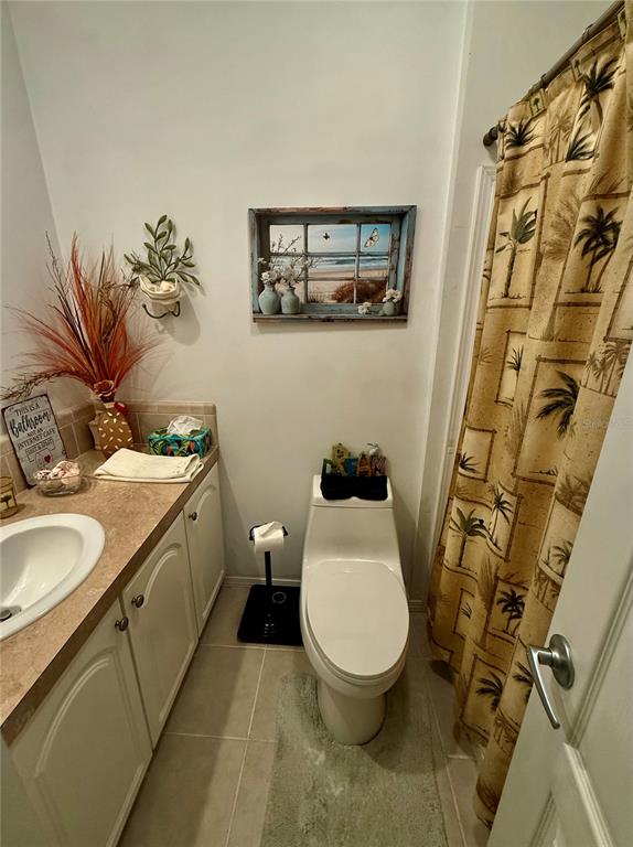 3530 Rossmere Road Port Charlotte, FL 33953 - Photo 18 of 32 a bathroom with a granite countertop toilet a sink and a mirror