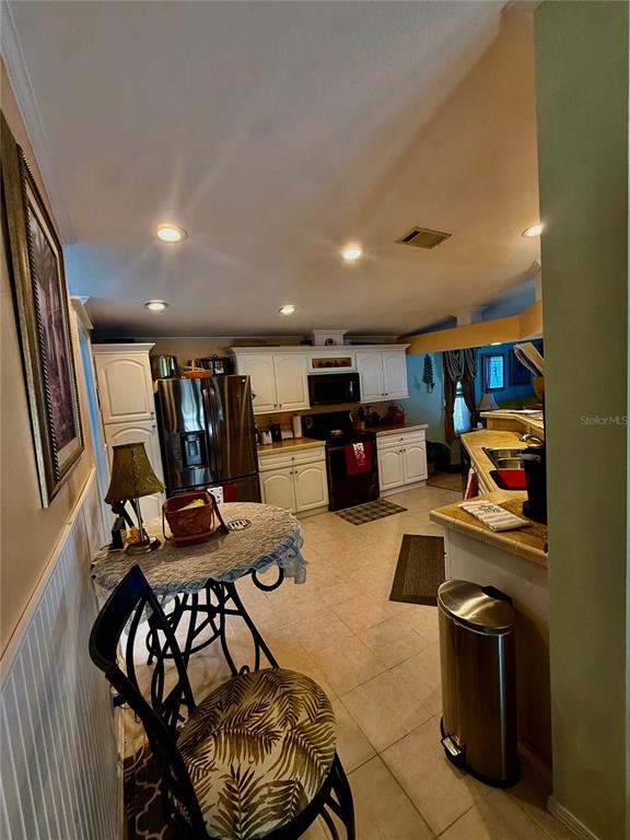 3530 Rossmere Road Port Charlotte, FL 33953 - Photo 21 of 32 a kitchen with stainless steel appliances kitchen island granite countertop a stove and a refrigerator