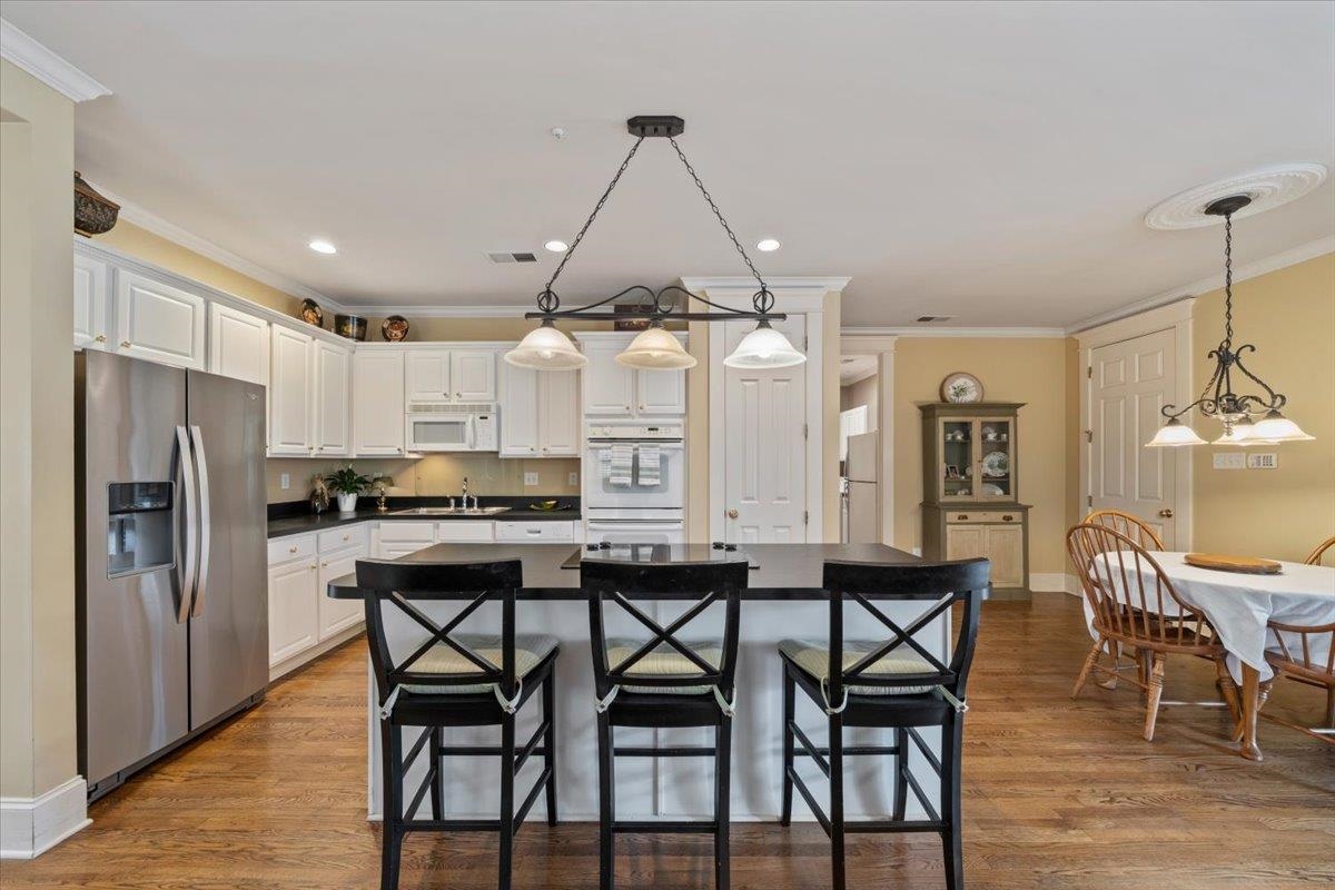 1436 Wolf Park Road Germantown, TN 38138 - Photo 13 of 34 a kitchen with stainless steel appliances granite countertop a dining table chairs refrigerator and cabinets