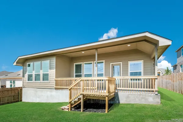 a view of a house with a deck and a yard