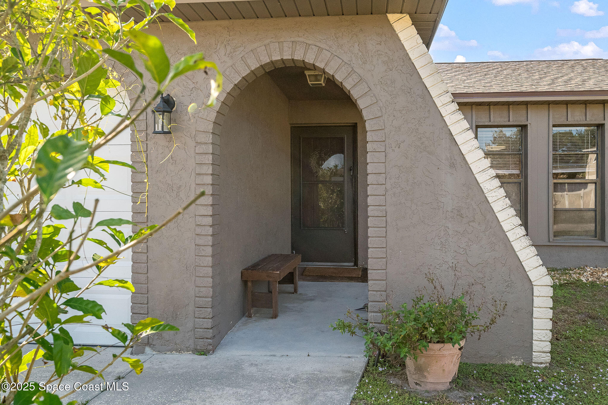 a view of a stone house with potted plants