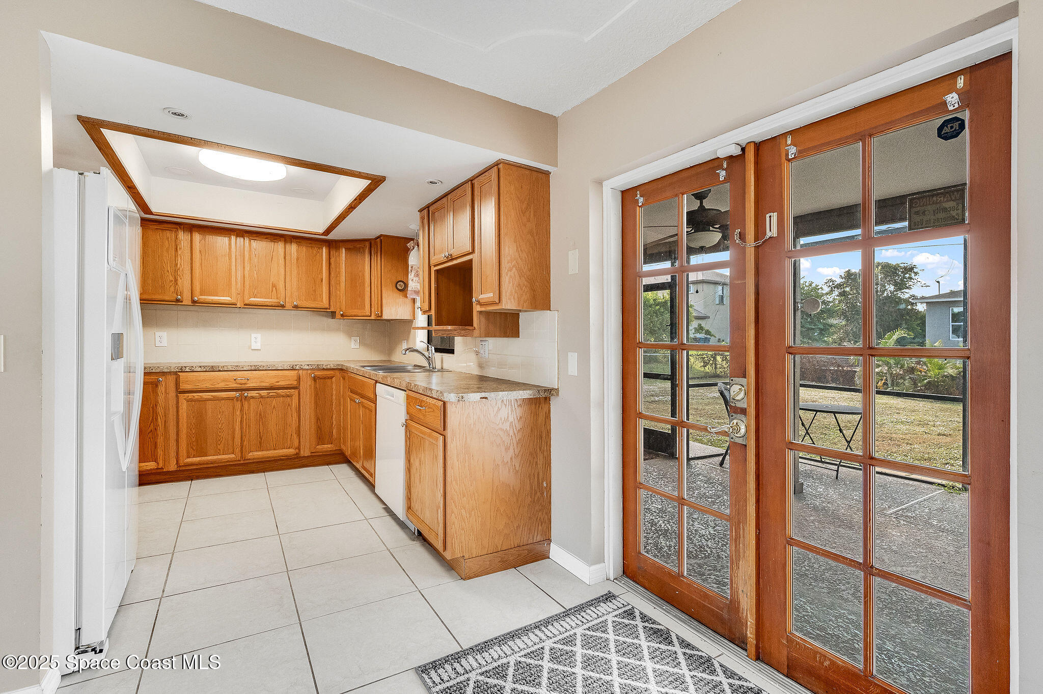 115 Angelo Road Southeast Palm Bay, FL 32909 - Photo 17 of 38 a kitchen with a refrigerator a sink and cabinets