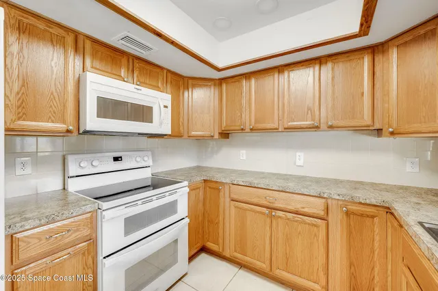 a kitchen with stainless steel appliances granite countertop a sink and a white cabinets