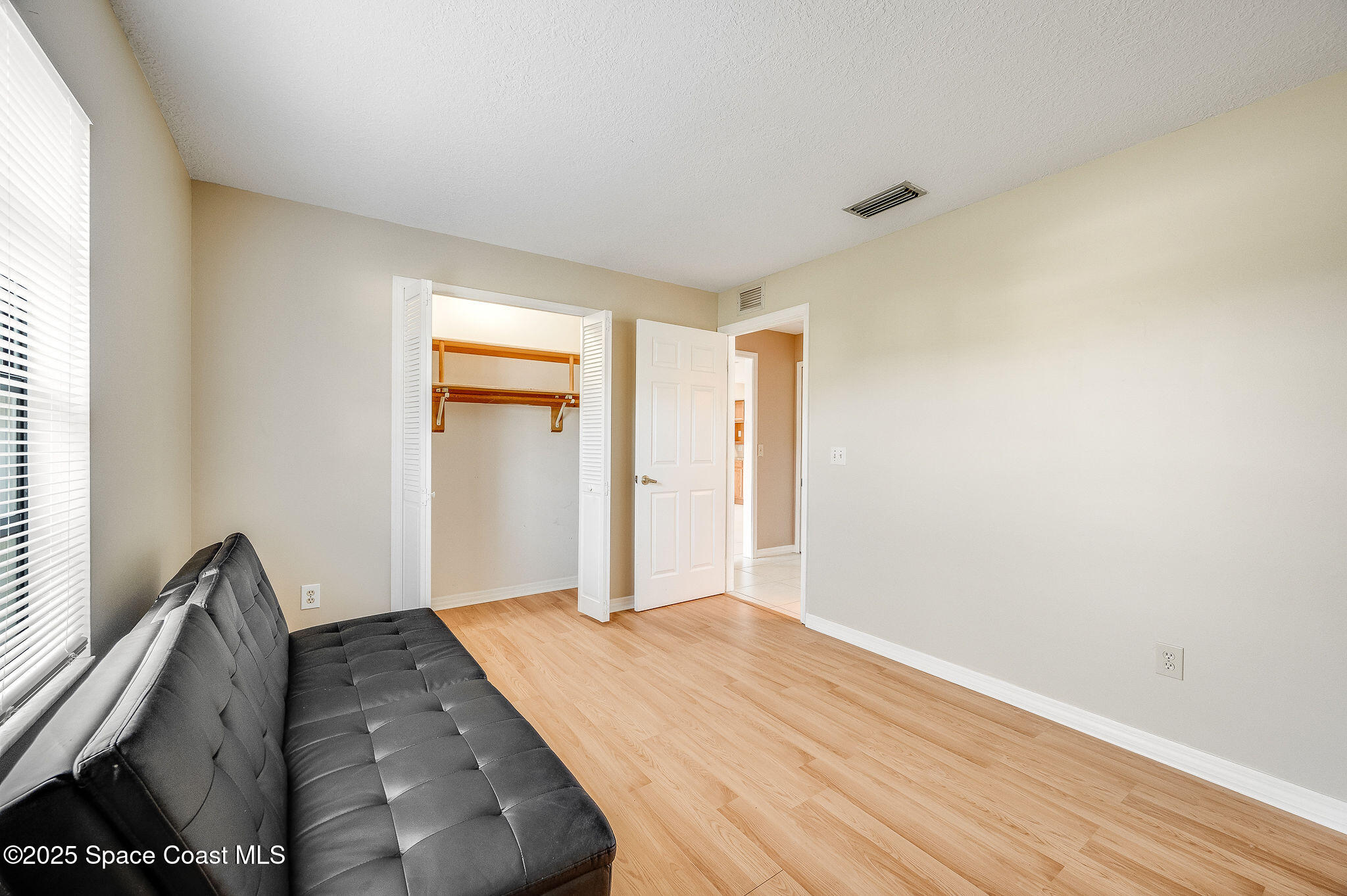 115 Angelo Road Southeast Palm Bay, FL 32909 - Photo 24 of 38 a bedroom with a bed and wooden floor