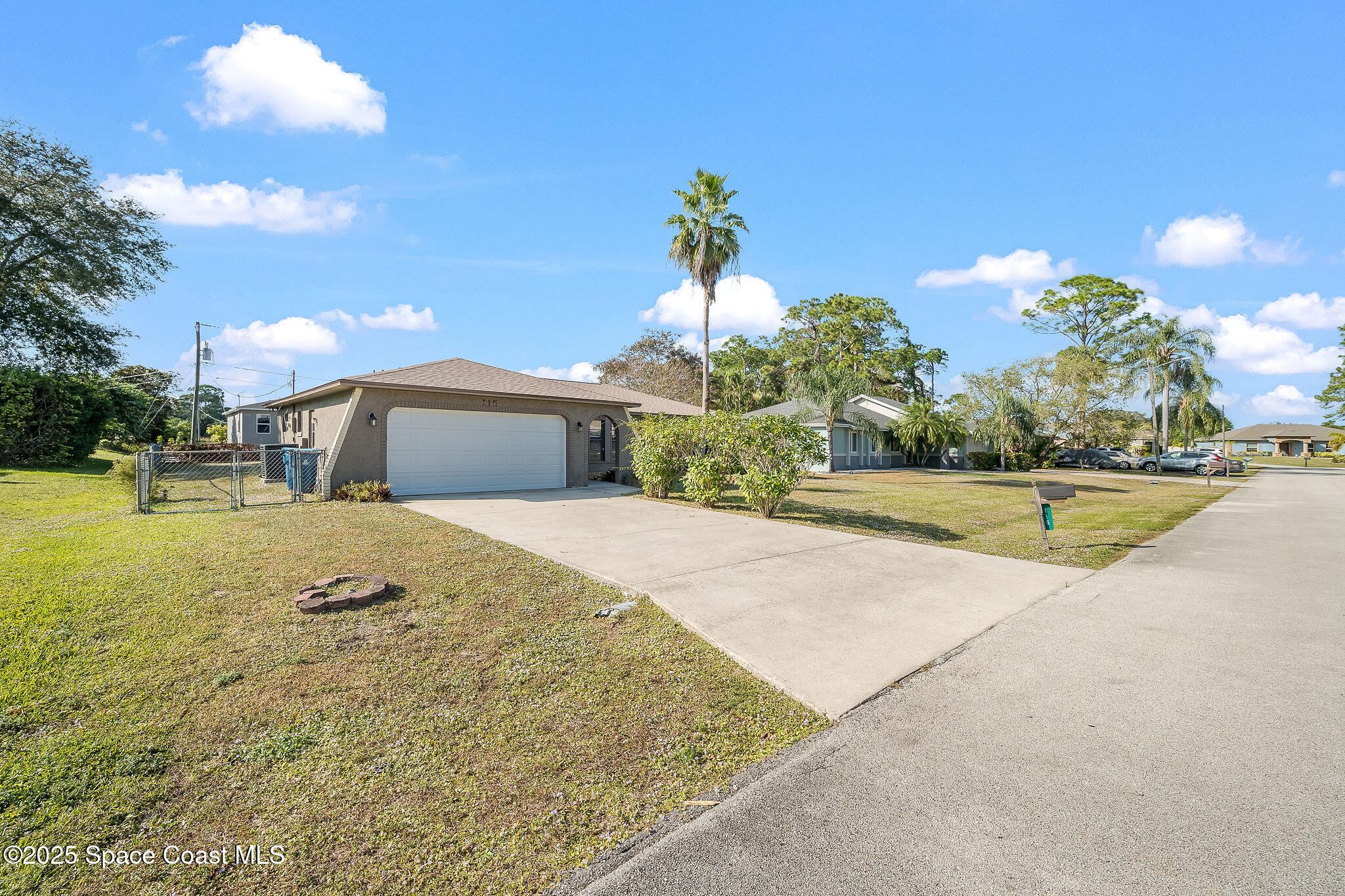 115 Angelo Road Southeast Palm Bay, FL 32909 - Photo 32 of 38 a front view of a house with a yard and garage